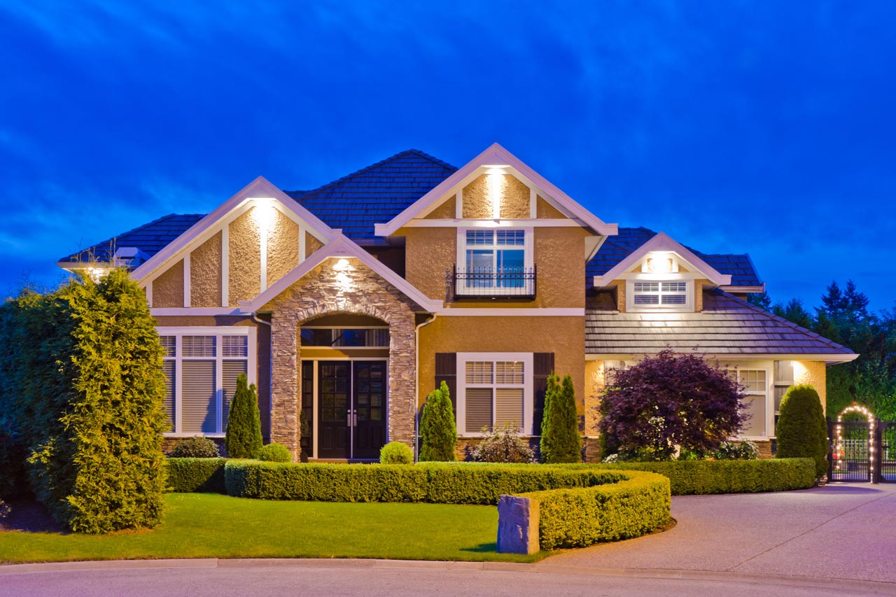 A luxury house with outdoor lighting at dusk