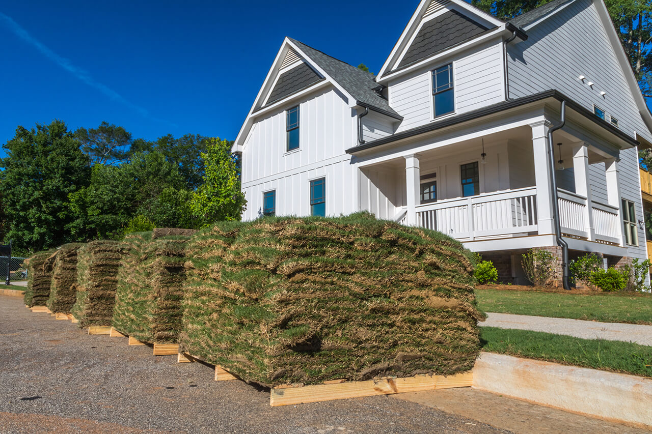 large pallets of new sod in front of a house