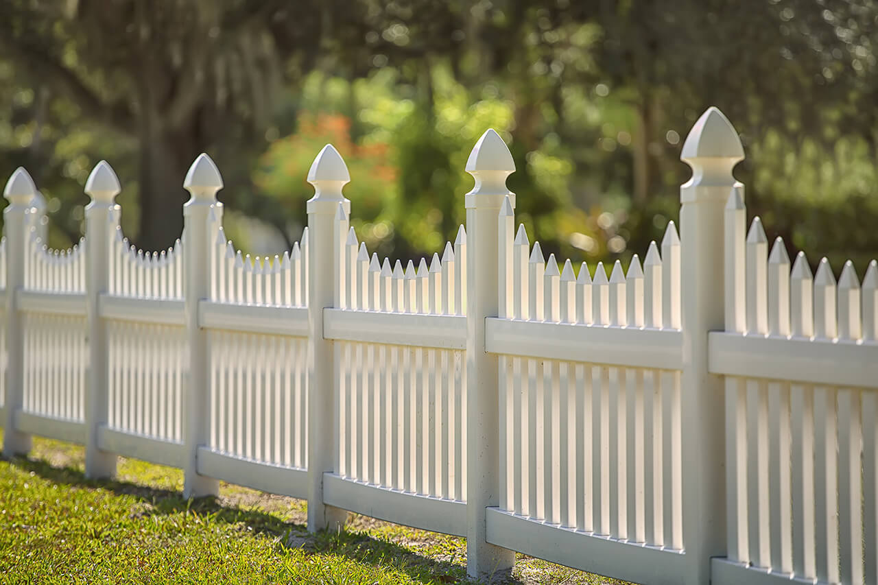 white scalloped vinyl picket fance around yard