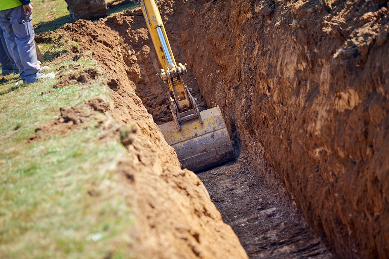 Excavator digging a trench