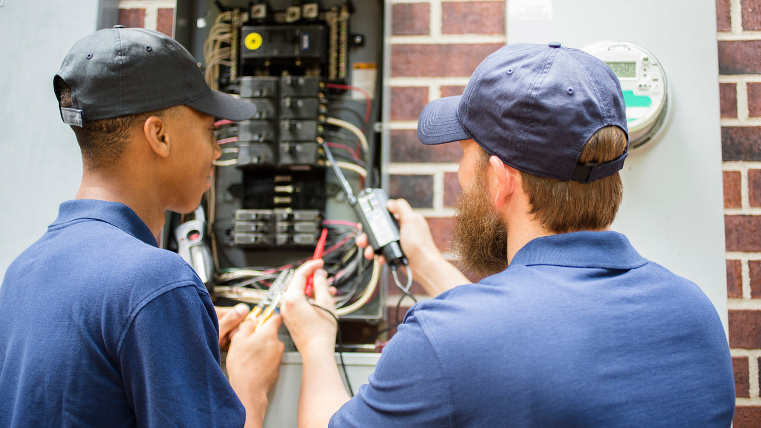 Electricians work on breaker box