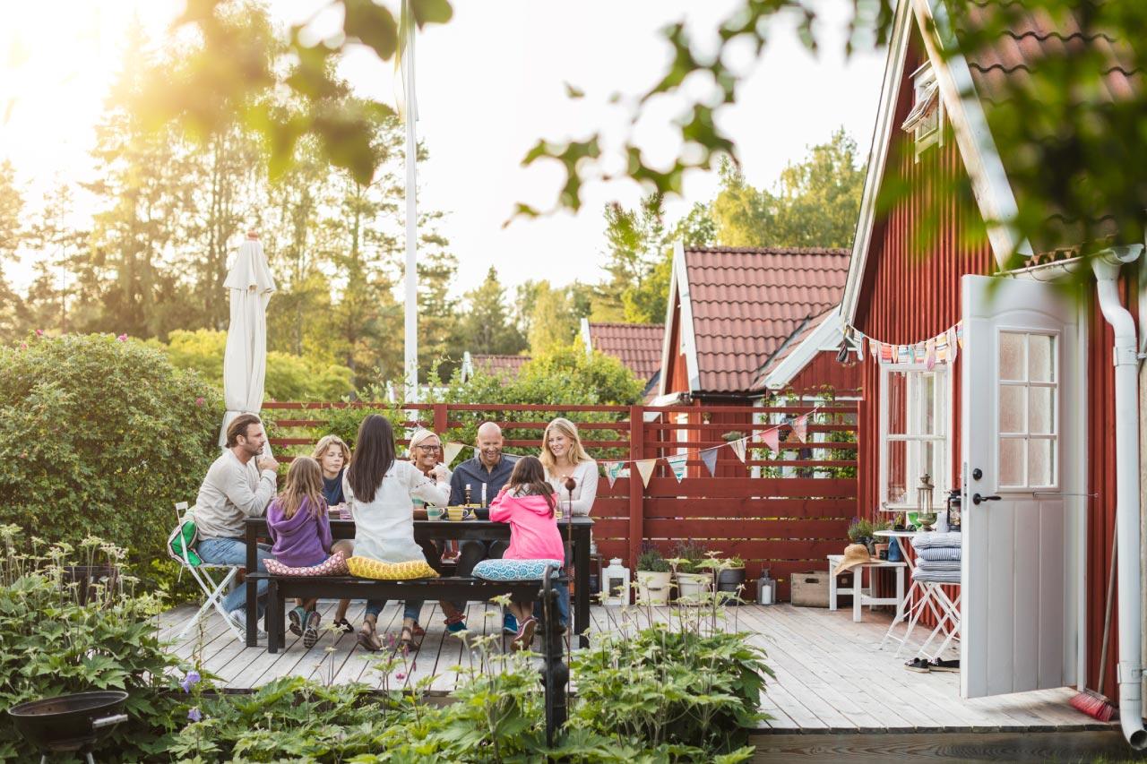 A happy family and friends eating at garden lunch party in backyard