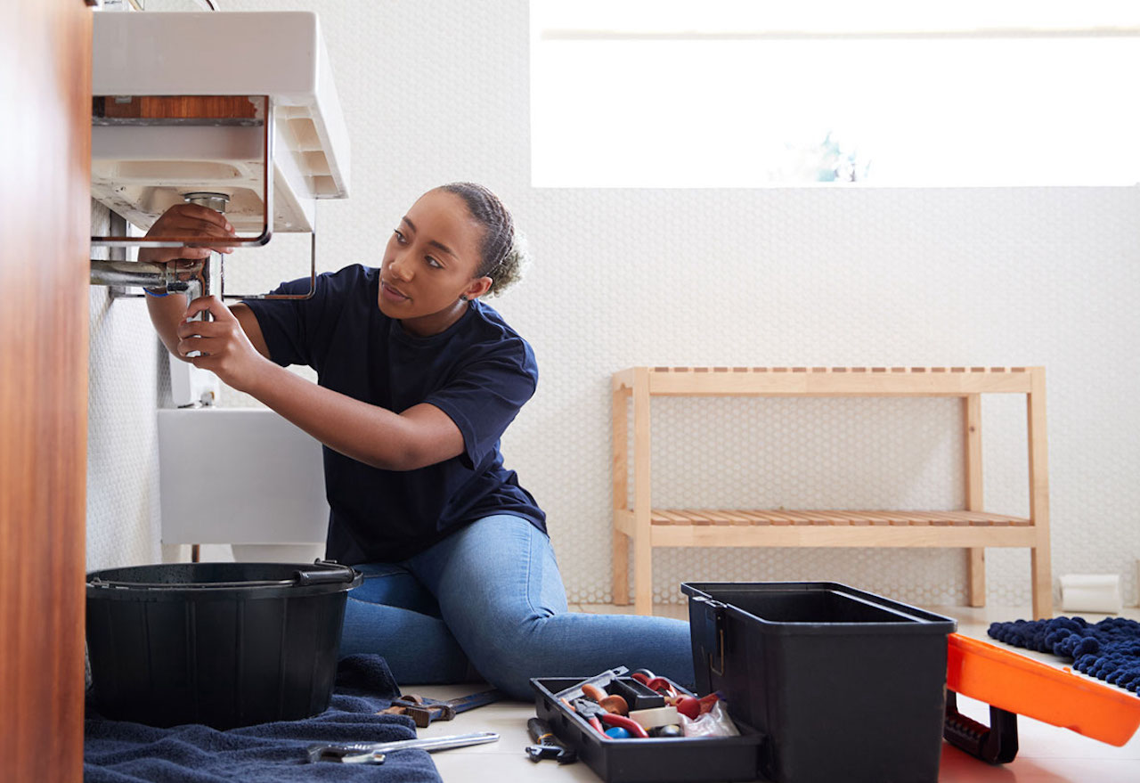 Plumber in the bathroom fixing a pipe