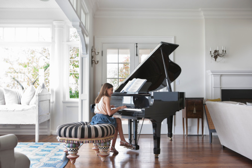 Girl playing grand piano in the living room
