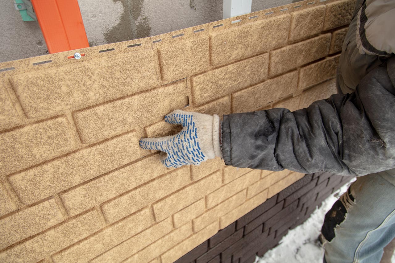 professional installing brick siding on exterior of home