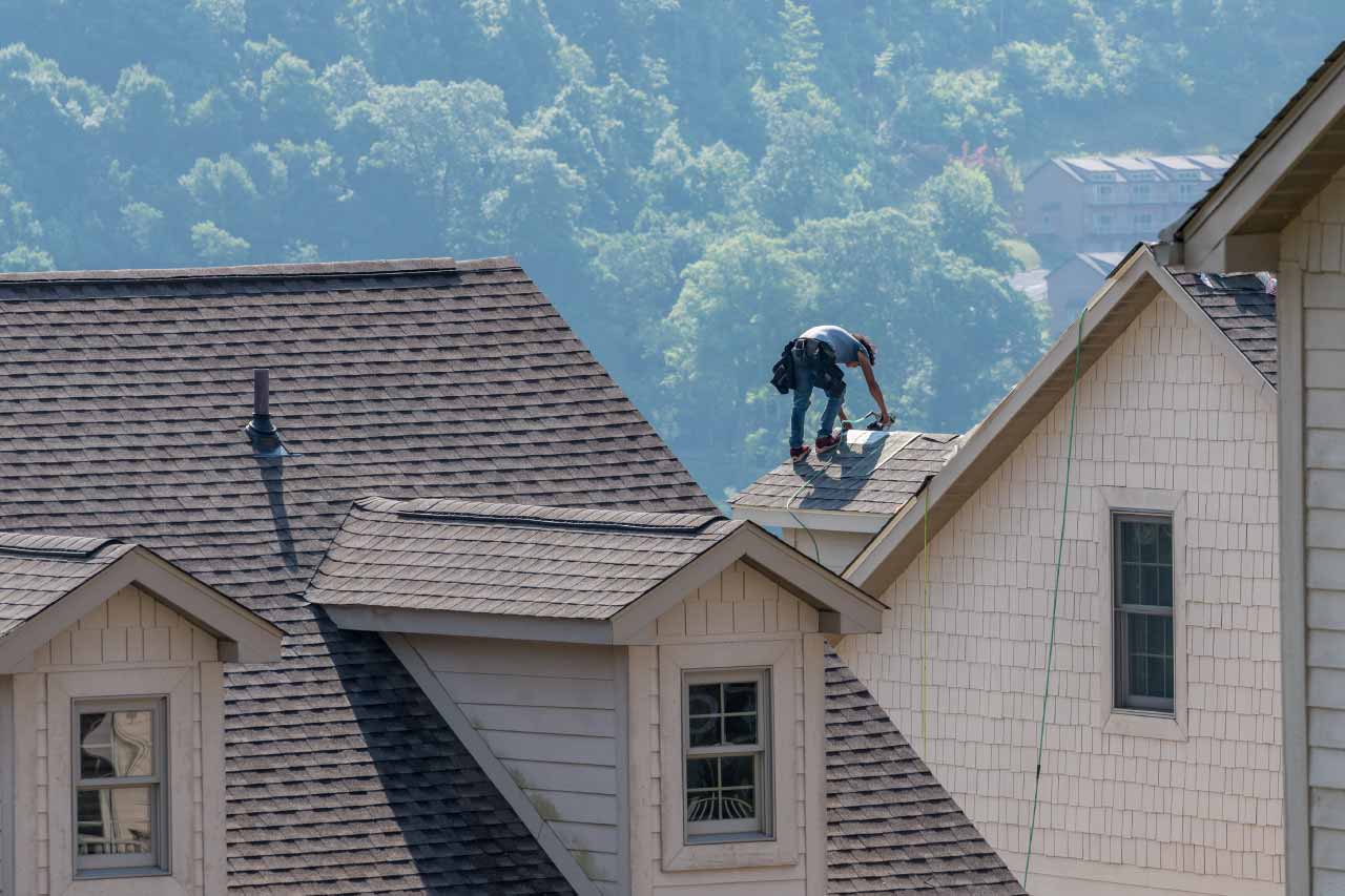 Roofing contractor replacing the old shingles