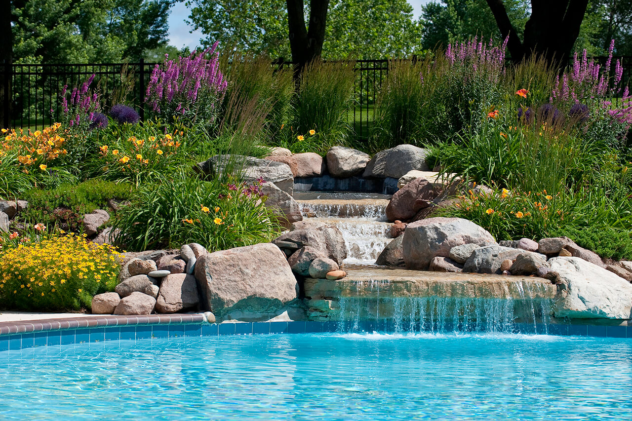 waterall feature with landscaping in a backyard swimming pool